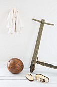 Old wooden scooter, leather ball and white child's shoes
