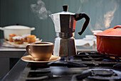 Espresso-Bereiter auf Gasherd, daneben Kaffeetasse