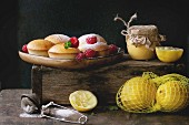 Homemade lemon muffin cupcakes with fresh raspberries, sugar powder, mint, served with jar of lemon curd and lemons