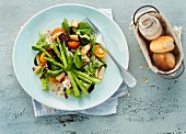A fresh summer salad with green baby asparagus and pizza bread