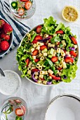 Nudelsalat mit Erdbeeren, Gurken und Kräutern in Schüssel (Aufsicht)