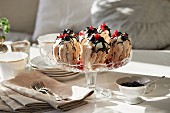 A meringue dessert with cream, berries and chocolate sauce