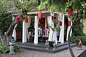 Garden party in pavilion surrounded by red lanterns
