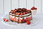 A heart shaped chocolate and strawberry cake with cream