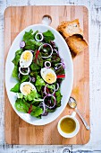 Salad with boiled eggs and vinaigrette on a chopping board