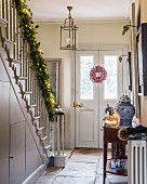 Festively decorated hall with garland along staircase handrail