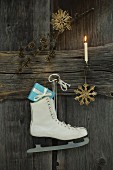 Schlittschuh mit Weihnachtsdekoration an Holzwand