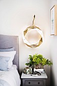 Modern aluminum wreath with lighting above the bedside table