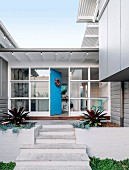 Stairs to the architect's house with glass front and blue front door