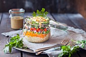 Regenbogen-Salat in einem Glas (Quinoa, Karotten, Erbsen, Rotkohl, Paprika und Mungobohnensprossen)