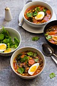 White bean soup with harissa, honey, egg and celery leaves
