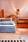Simple bed on platform in wood-clad attic room