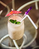 A smoothie with mint and a cocktail umbrella
