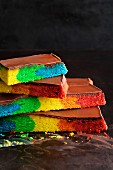 Colourful rainbow cake topped with chocolate glaze