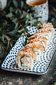 Sushi rolls with eel, tempura prawns, fresh cheese, and cucumbers