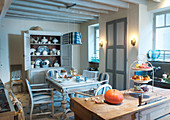 Dining table in grey and white country-house kitchen