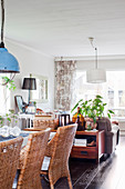 Rattan chairs around dining table in open-plan interior