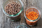 Brown and red lentils in glass jars