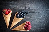 Various berries in ice cream cones