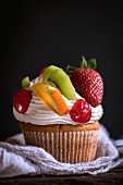 A cupcake with fresh fruit and cream