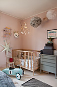 Gitterbett im Kinderzimmer mit rosafarbenen Wänden