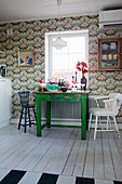 Green table and retro wallpaper in kitchen