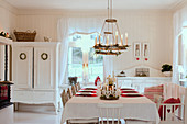 Festively set table in white country-house-style dining room