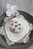 Homemade gingerbread with icing sugar dusted in a star pattern, on a lace doily (gluten-free)