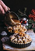 Christmas apple pie with blurred motion of caramel splashing on the top