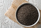 Black chia seeds in a bowl on a rustic wooden table