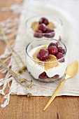 A layered dessert with cherries and yogurt cream