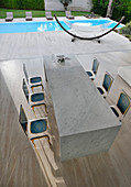 Transparente Stühle mit Barockprint am Marmortisch vor dem Pool