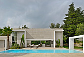 Modern architect-designed house with pool under cloudy sky