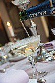 Glass of Champagne being poured on set table