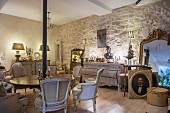 Antique furnishings in renovated period apartment with stone wall