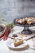Rhubarb and frangipani tart with pistachios on a plate and a cake stand