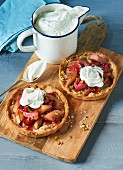 Rhubarb tartlets with whipped cream on a wooden board