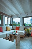 Wicker sofa and colourful scatter cushions in rustic living room