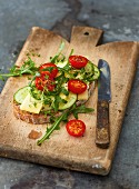 Wholemeal bread topped with cheese, cucumber, rocket and tomatoes