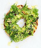 A grilled bagel with avocado cream and dill (close up)