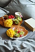 Frühstück im Bett mit Pancakes, Obst, Joghurt und Ahornsirup
