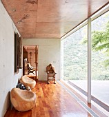 Holzkunst im Flur mit Fensterfront, Betonwänden und Holzboden