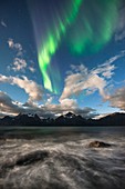 Aurora borealis over coastal mountains