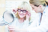 Optometrist helping senior woman