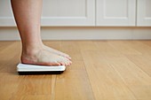 Woman standing on weighing scales