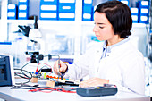 Female engineer soldering a circuit board