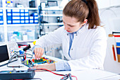 Female engineer working on a circuit board