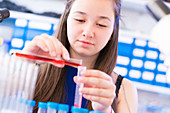Chemistry student pouring liquid into test tube