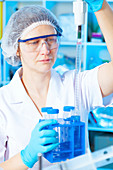 Woman measuring liquid in chemical laboratory