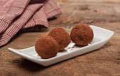 Three chocolate truffles with cocoa powder